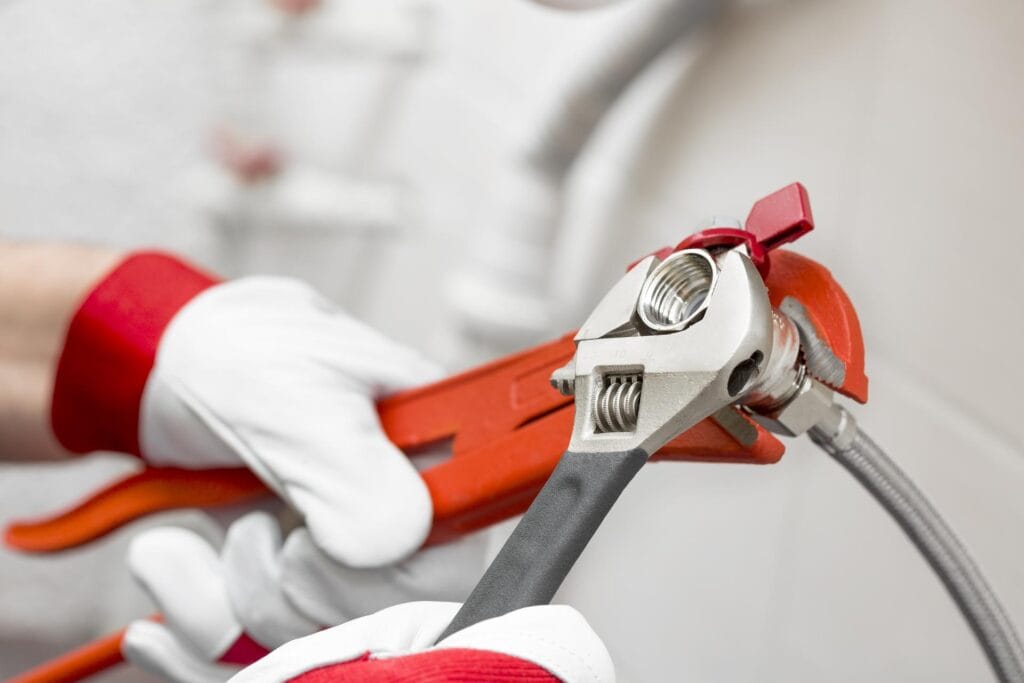 Plumber holding pipe wrenches for an emergency repair in Tarpon Springs