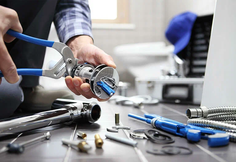 Technician repairing a plumbing fixture with professional tools in Tarpon Springs