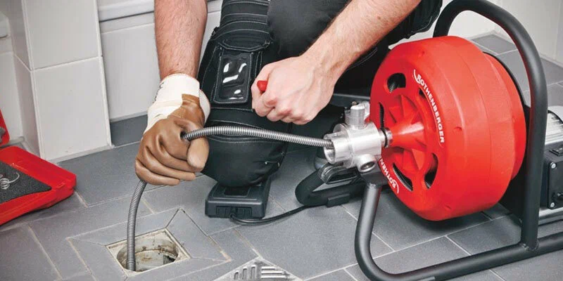 Plumber using a drain-cleaning machine in Tarpon Springs