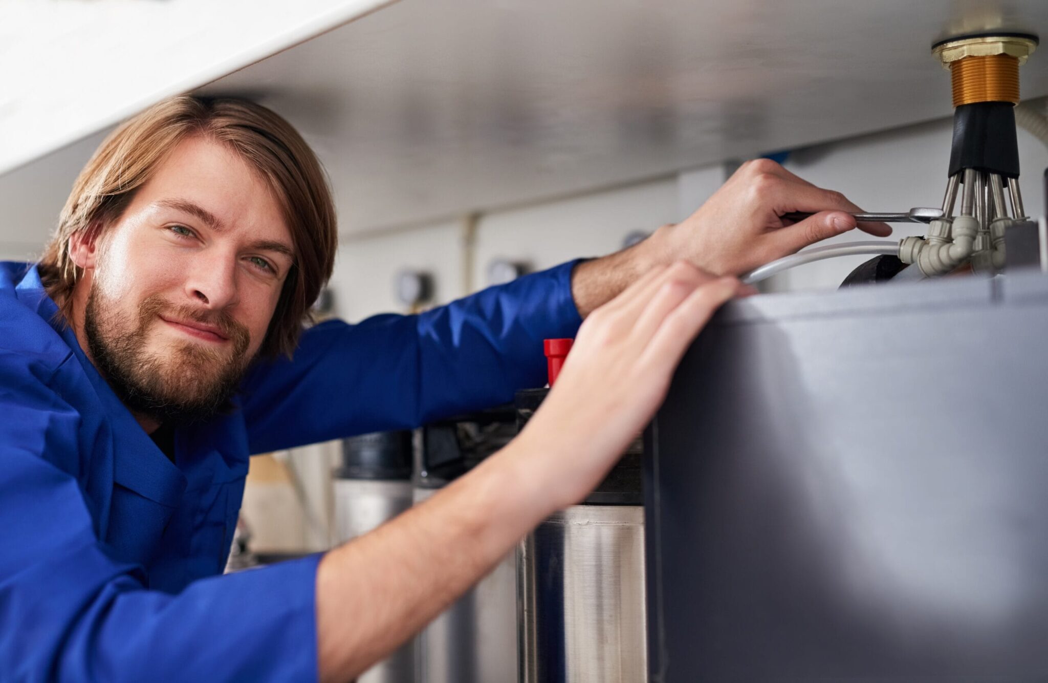 Technician servicing a residential water heater tank in Tarpon Springs